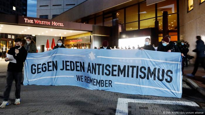 Des manifestants devant l'hôtel Westin Leipzig tenant une banderole contre tout antisémitisme