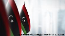 Small flags of Libya on a blurry background of the city.