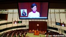 Hong Kong Chief Executive Carrie Lam is seen on a tv screen as she delivers her annual policy address at the Legislative Council in Hong Kong, China October 6, 2021. REUTERS/Lam Yik