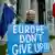 A man holds a sign 'Europe don't give up!"