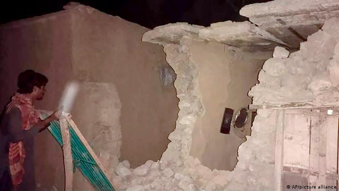 A local resident looks at his damaged house following a severe earthquake in southern Pakistan 