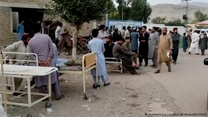 People gather outside a hospital following a 5.7 earthquake in Balochistan province, Pakistan