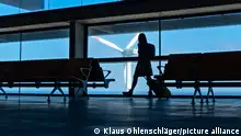 Eine Frau zieht am Flughafen von La Palma einen Trolley durch eine leere Wartezone