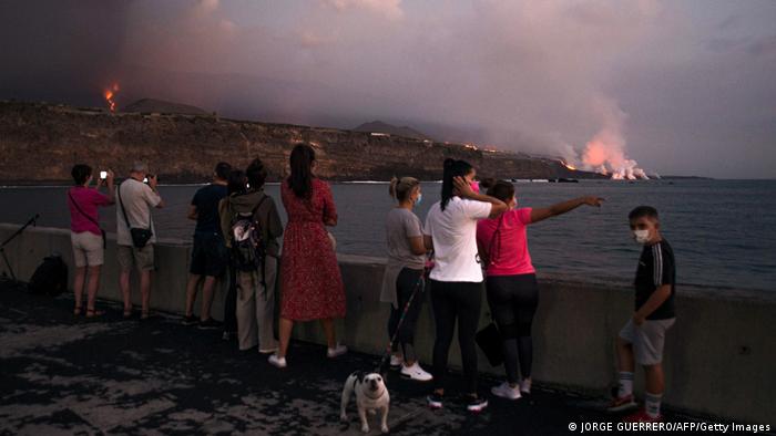 People observe lava flow of Cumbre Vieja volcano on La Palma