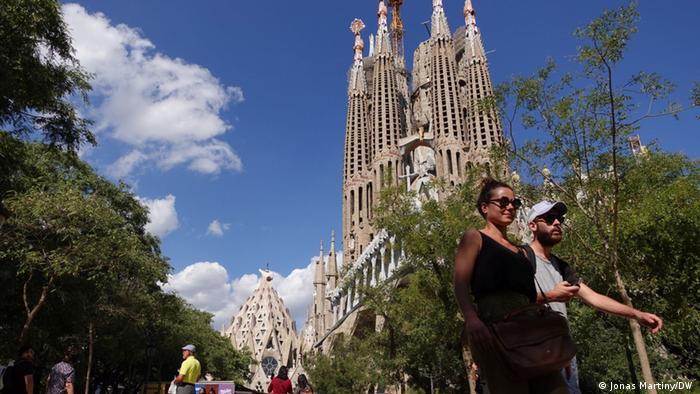 People walking with the Sagrada Familia in the background