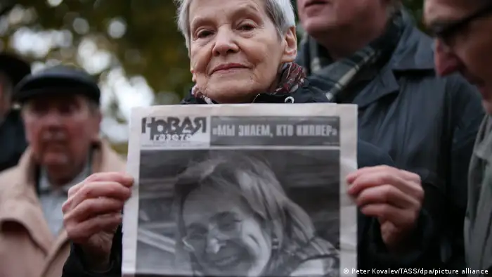 在悼念俄罗斯记者波利特科夫斯卡娅的活动中，一位老妇人手持她的肖像照片
