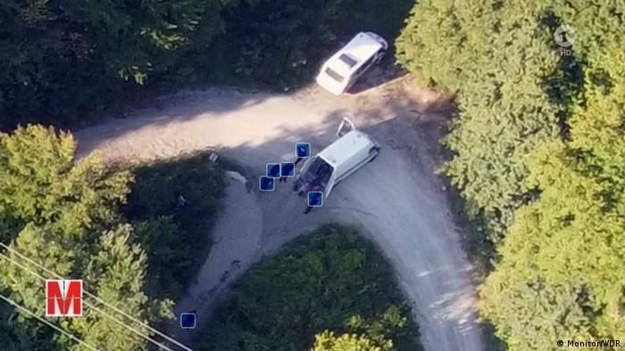 Aerial view of two white vans in a wooded area on the border between Croatia and Bosnia