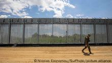 An armed military personnel is patroling along the fence, while there is a Turkish watchtower in the background behind the new fence. Greece is reinforcing the Greek Turkish borders with personnel, cameras, drones, heavy vehicles, FRONTEX officers but also with a 5 meter tall fence. The fence is actually a concrete filled, a construction for at least 40KM, a long coverage in the wetlands of Evros river (Meric in Turkish), Greece's river border with Turkey. EU is supporting the border fortification financially. Asylum seekers, migrants and refugees used Evros as an entrance point to Europe, while in March 2020 a huge wave of thousands of people tried to cross the borders. Poros Village, Evros region, Greece on June 18, 2021 (Photo by Nicolas Economou/NurPhoto)