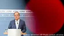 In this photo taken with a television camera control light in the foreground, Christian Democratic Union party chairman Armin Laschet speaks to media at the party's headquarters in Berlin, Thursday, Oct. 7, 2021. (AP Photo/Markus Schreiber)