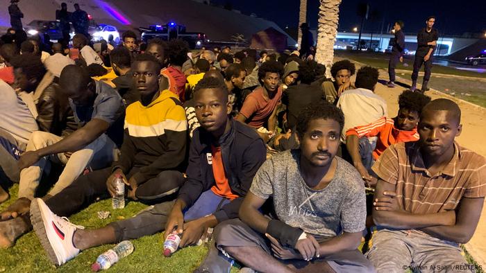 Migrants wait after they were detained by Libyan security forces in Tripoli, Libya, October 8, 2021.
