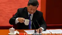 Chinese President Xi Jinping drinks as he delivers a speech at an event commemorating the 110th anniversary of Xinhai Revolution at the Great Hall of the People in Beijing, Saturday, Oct. 9, 2021. Xi said on Saturday reunification with Taiwan must happen and will happen peacefully, despite a ratcheting-up of China's threats to attack the island. (AP Photo/Andy Wong)