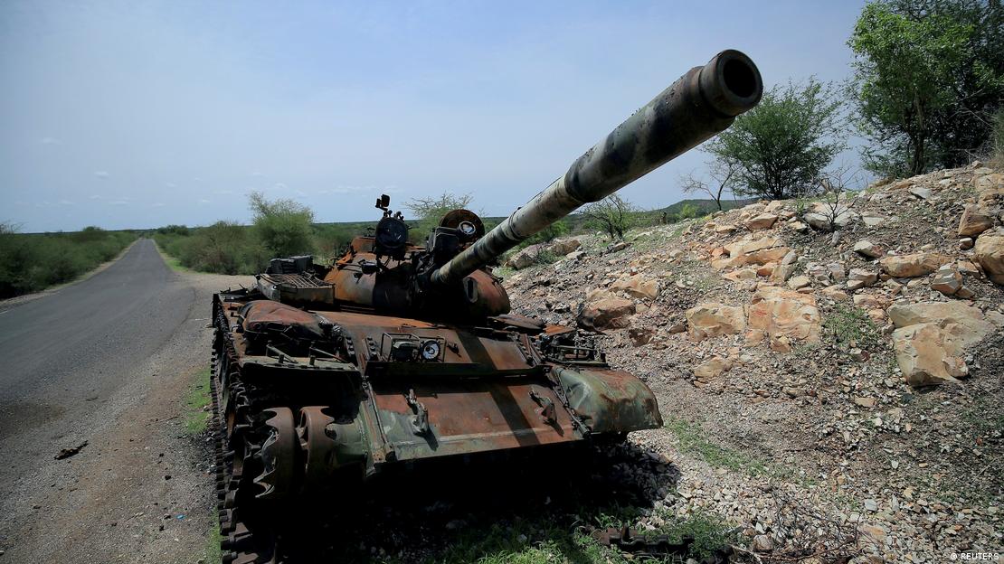 A tank damaged during fighting between Ethiopian federal forces and Tigray forces stands on the side of the road