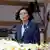 Presidente taiwanesa Tsai Ing-wen de blazer azul escuro fala num púlpito. 