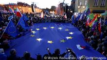 Participants hold a large EU flag as they take part in a pro-EU demonstration following a ruling of the Constitutional Court against the primacy of EU law in Poland, in Warsaw on October 10, 2021. - Tens of thousands of Poles rallied on October 10 in defence of their country's EU membership, after Poland's top court last week issued a landmark ruling against the primacy of EU law. The pro-EU demonstrations were called by former EU chief Donald Tusk, now leader of the country's main opposition grouping, Civic Platform, who has warned of the prospect of a Polexit. (Photo by Wojtek Radwanski / AFP) (Photo by WOJTEK RADWANSKI/AFP via Getty Images)