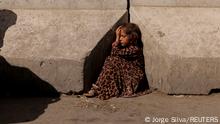 A girl sits between concrete barriers in Kabul, Afghanistan October 7, 2021. REUTERS/Jorge Silva TPX IMAGES OF THE DAY