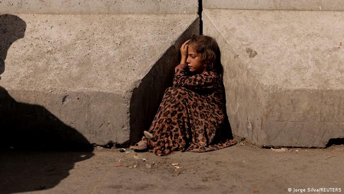 Afghanistan Kabul | Mädchen sitzt zwischen Betonbarrieren