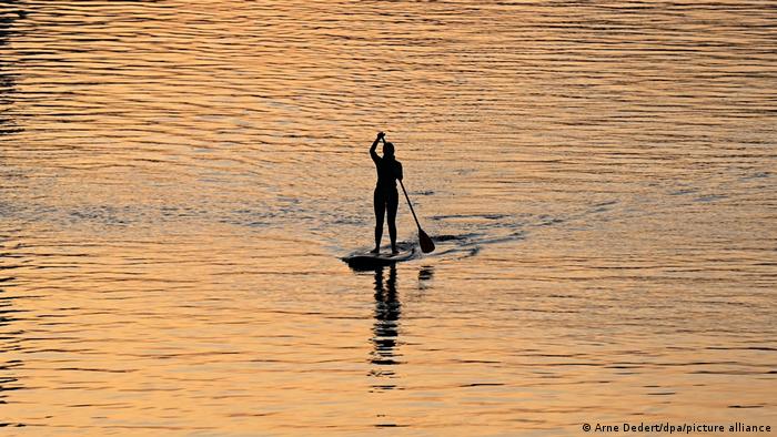 Una mujer navega sobre un lago con un surf de remo, cerca de Fráncfort.