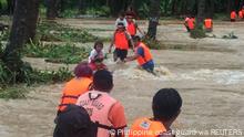 12.10.2021, Brooke's Point, Palawan, Philipinen, People cross floodwaters caused by tropical cyclone Kompasu during an evacuation assisted by the Philippine Coast Guard (PCG) at Brooke's Point, Palawan, in the Philippines, Ocotober 12, 2021, in this image obtained via social media. Philippine Coast Guard via REUTERS ATTENTION EDITORS - THIS IMAGE HAS BEEN SUPPLIED BY A THIRD PARTY. NO RESALES. NO ARCHIVES. MANDATORY CREDIT.