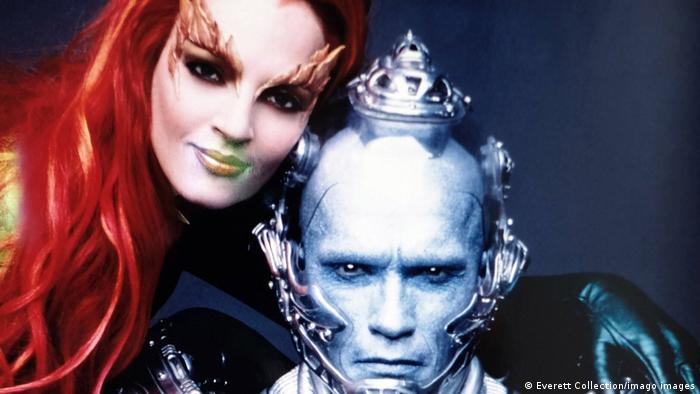 Uma Thurman, with long red hair as Poison Ivy, and Arnold Schwarzenegger as Mr. Freeze, look in the camera.