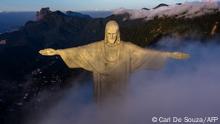 The sun rises in front of the Christ the Redeemer statue in Rio de Janeiro on March 24, 2021. - Christ the Redeemer is celebrating its 90th anniversary in October 2021 and is receiving restoration work to ensure that it looks its best for the public and visiting tourists. (Photo by CARL DE SOUZA / AFP)