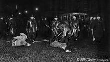 (Archive) Photo prise à Paris le 1 décembre 1961, pendant la guerre d'indépendance algérienne, d'une manifestation organisée entre la place de la Bastille et l'Hôtel de Ville pour protester contre les actions terroristes de l'OAS (Organisation Armée secrète). Les manifestants appelés par la CGT, la CFTC et l'UNEF arborant des pancartes proclamant OAS Assassins et Non à la guerre d'Algérie se sont violemment heurtés aux les forces de l'ordre. Matraques à la main, des policiers sont penchés sur des manifestants blessés à terre. AFP PHOTO (Photo by - / AFP) (Photo by -/AFP via Getty Images)