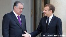 French President Emmanuel Macron (R) greets President of Tajikistan Emomali Rahmon at The Elysee Presidential Palace in Paris on October 13, 2021. (Photo by Ludovic MARIN / AFP)