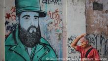 Ein Mann mit Mund-Nasen-Schutz geht vor einem Wandbild des ehemaligen kubanischen Präsidenten Fidel Castro. In Kuba sind 5310 Menschen an Covid-19 erkrankt.