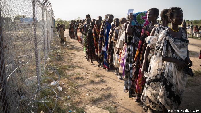 Mujeres negras esperan por la repartición de comida del Programa Mundial de Alimentos en un fila en Sudan del Sur.