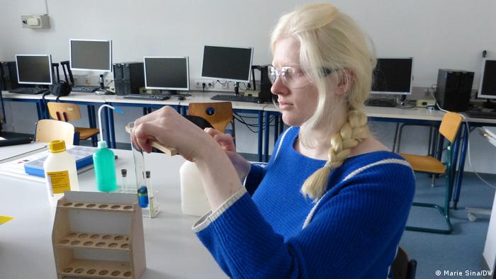 Die sehbehinderte Schülerin Alexandra Dunayeva hält ein Reagenzglas mit einer Zange