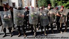 Lebanese army stand guard near the Justice Palace as supporters of the Shiite Hezbollah and Amal groups protest against Judge Tarek Bitar who is investigating last year's deadly seaport blast, in Beirut, Lebanon, Thursday, Oct. 14, 2021. (AP Photo/Hussein Malla)
