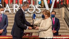 Germany's Chancellor Angela Merkel (R) receives the Carlos V European Award from Spain's King Felipe VI during a ceremony at the Royal Monastery of Yuste, in Cuacos de Yuste, on October 14, 2021. - The Carlos V award is given to leaders who have stood out for their commitment to the process of the European union or their contribution to the exaltation of the cultural, scientific and historical values of Europe. (Photo by Jero MORALES / POOL / AFP)