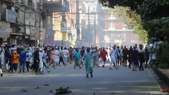 A large group of people gather in a hazy street