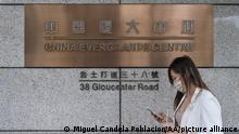 A pedestrian walks past the Shenzhen-based property management company China Evergrande Centre.