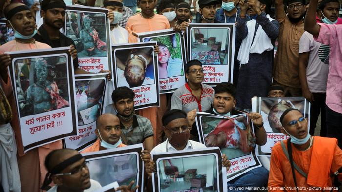 Protesters hold signs with images of injured and killed people