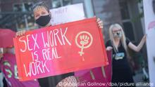 Eine Teilnehmerin hält während einer Demonstration zum Arbeitsverbot von Sexarbeiterinnen während der Corona-Pandemie ein Schild mit der Aufschrift Sex work is real work (dt. Sexarbeit ist echte Arbeit) in der Hand. Seit dem 19. Juli hat die Stadt Stuttgart ein Komplettverbot der Prostitution ausgerufen. Stuttgart 06.08.2020