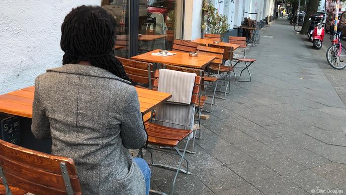La travailleuse du sexe Olivia est assise dos à la caméra dans un café