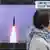 سيدة تمر أمام شاشة تلفزيونية تظهر إطلاق كوريا الشمالية صواريخ في برنامج إخباري في طوكيو (19/10/2021)