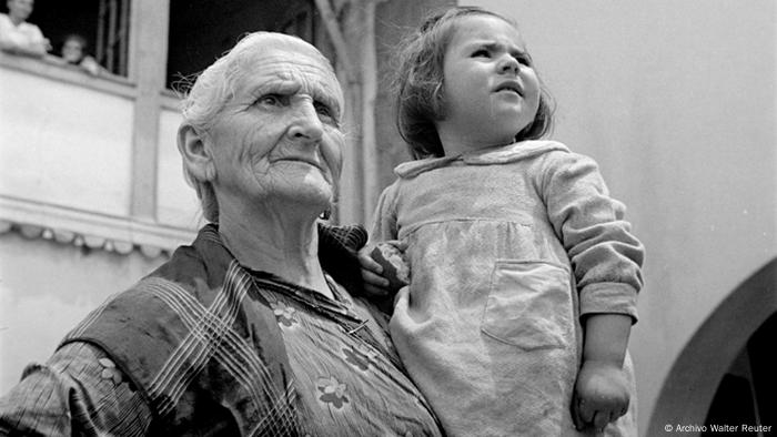 Una niña en brazos de una anciana.