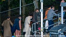 Ortskräfte aus Afghanistan gehen am frühen Morgen auf dem Gelände der DRK-Flüchtlingshilfe in der Erstaufnahmeeinrichtung zu ihrer Unterkunft. Gegen 4:30 Uhr am frühen Morgen sind zwei Busse vom Flughafen in Frankfurt am Main mit knapp 60 Ortskräften aus Afghanistan hier an der Zentralen Ausländerbehörde Brandenburgs angekommen. +++ dpa-Bildfunk +++