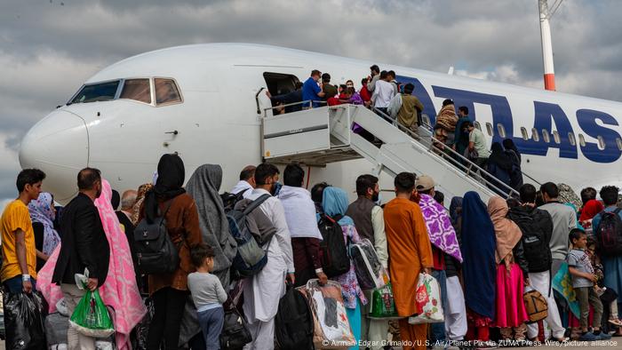 Afghan refugees board a Atlas Air commercial aircraft for transfer to the United States after evacuation from Kabul at Ramstein Air Base.