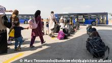 Schutzbedürftige Menschen gehen kurz nach dem Flug aus Kabul zu einem Bus. Die Bundeswehr hat ihre Evakuierungsmission für Deutsche und einheimische Ortskräfte in Afghanistan am Donnerstagmorgen fortgesetzt. +++ dpa-Bildfunk +++