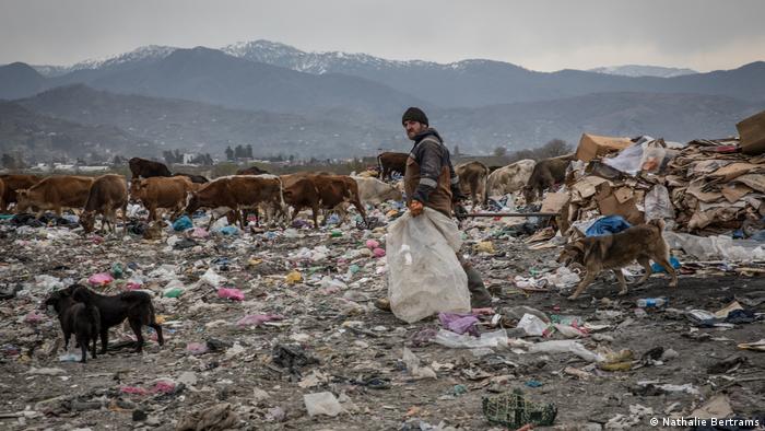 Ein Arbeiter sammelt Müll auf der Deponie von Gonio 