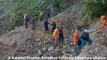 This photograph provided by India’s National Disaster Response Force (NDRF) shows NDRF personnel rescuing civilians stranded following heavy rains at Chhara village near Nainital, Uttarakhand, Wednesday, Oct. 20, 2021. Nainital remained cut off from the rest of the state as roads leading to it were either blocked by landslides or washed away. ( National Disaster Response Force via AP)