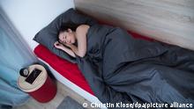 ILLUSTRATION - Eine junge Frau liegt am 30.04.2018 in einem Apartment in Hamburg in ihrem Bett und schlaeft (gestellte Szene). Foto: Christin Klose || Modellfreigabe vorhanden