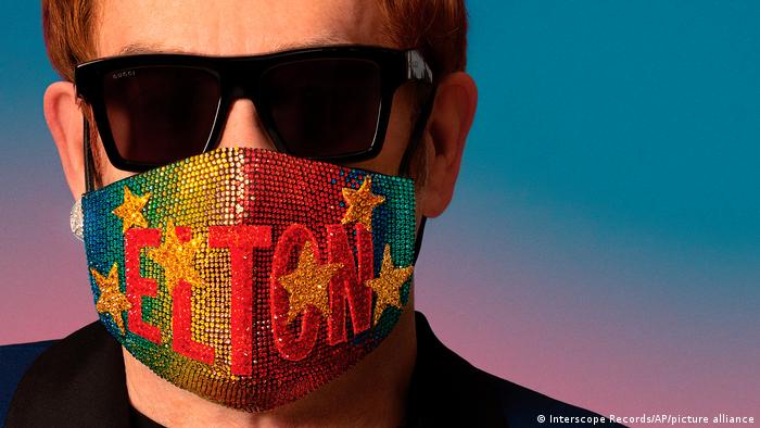 Elton John wearing a colorful face mask with the word Elton and stars on it | Album Cover The Lockdown Sessions