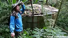 Plantation owner Chien Shun-yih standing next to his self-built water storage tank
