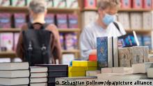 Zwei Frauen lesen am ersten Tag für Fachbesucher auf der Frankfurter Buchmesse 2021 am Stand von Bastei Lübbe. Nach der pandemiebedingten Pause 2020 darf die Frankfurter Buchmesse in diesem Jahr wieder mit Publikum stattfinden.