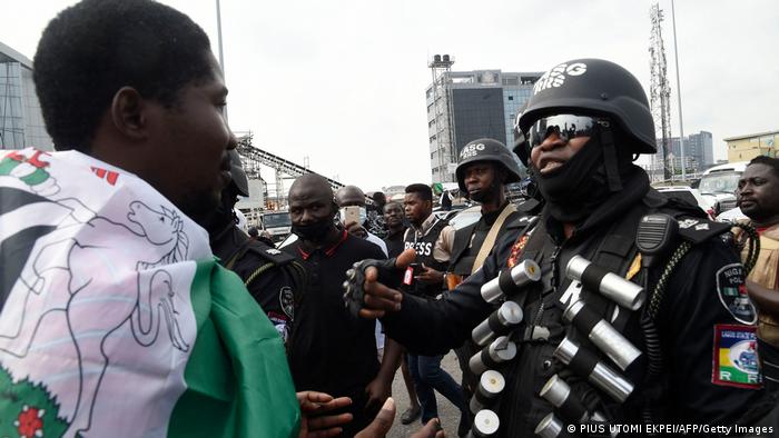An activist faces heavily-armed policemen in Nigeria