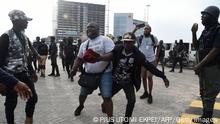 A journalist Abisola Alowode, who was mistaken for a protester, is arrested by Police officers during a protest to commemorate one year anniversary of EndSars, a protest movement against police brutality at the Lekki tollgate in Lagos, on October 20, 2021. - Hundreds of youth match to commemorate one year anniversary of Endars protest that rocked the major cities across the country on October 20, 2020. (Photo by PIUS UTOMI EKPEI / AFP) (Photo by PIUS UTOMI EKPEI/AFP via Getty Images)