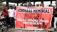 People carry a banner during a protest to commemorate one year anniversary of EndSars, a protest movement against police brutality at the Lekki tollgate in Lagos, on October 20, 2021. - Hundreds of youth match to commemorate one year anniversary of Endars protest that rocked the major cities across the country on October 20, 2020. (Photo by PIUS UTOMI EKPEI / AFP) (Photo by PIUS UTOMI EKPEI/AFP via Getty Images)